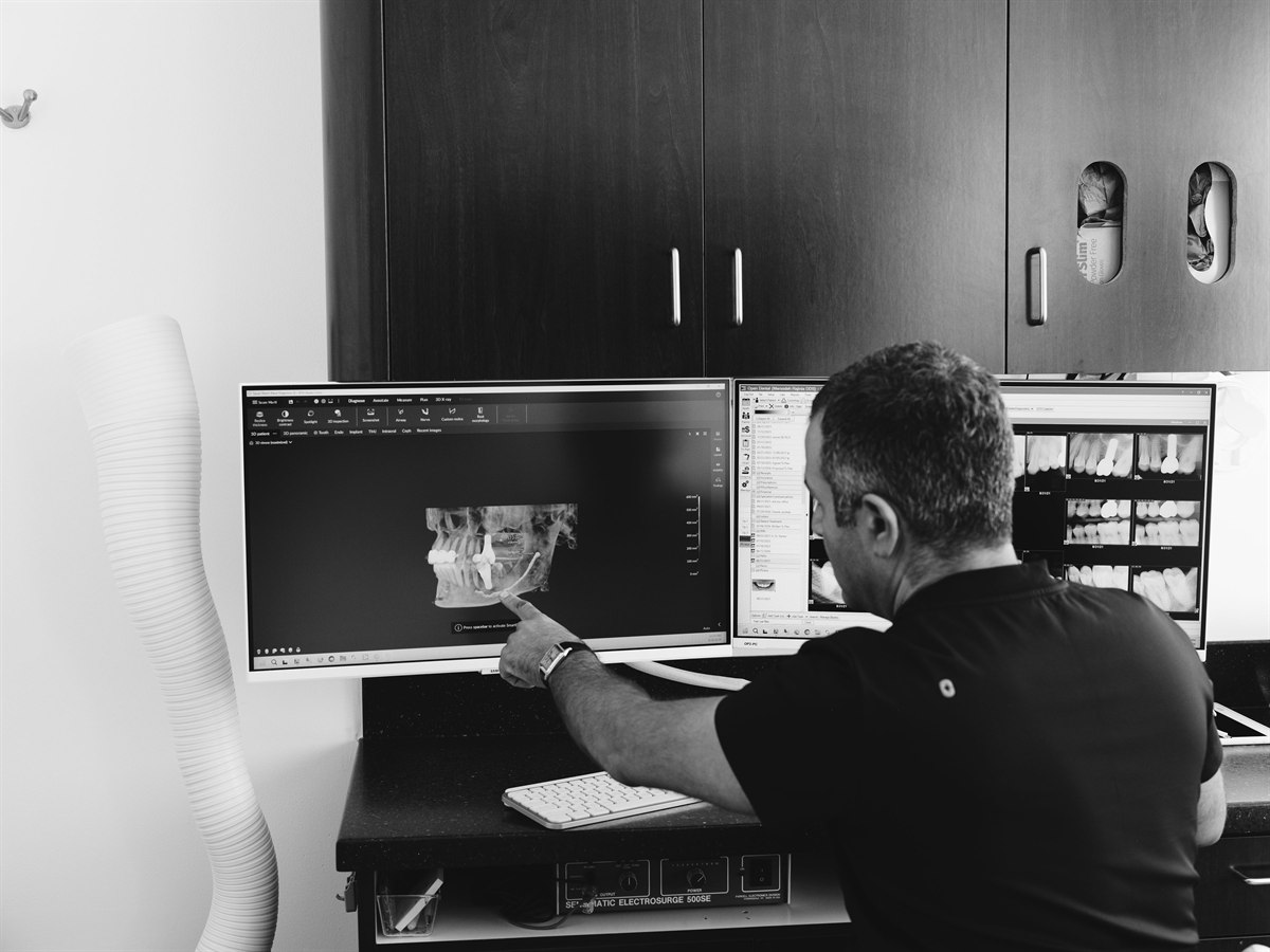 An ELEV8 dentist reviewing a 3D cone beam CT (CBCT) dental scan in Beverly Hills