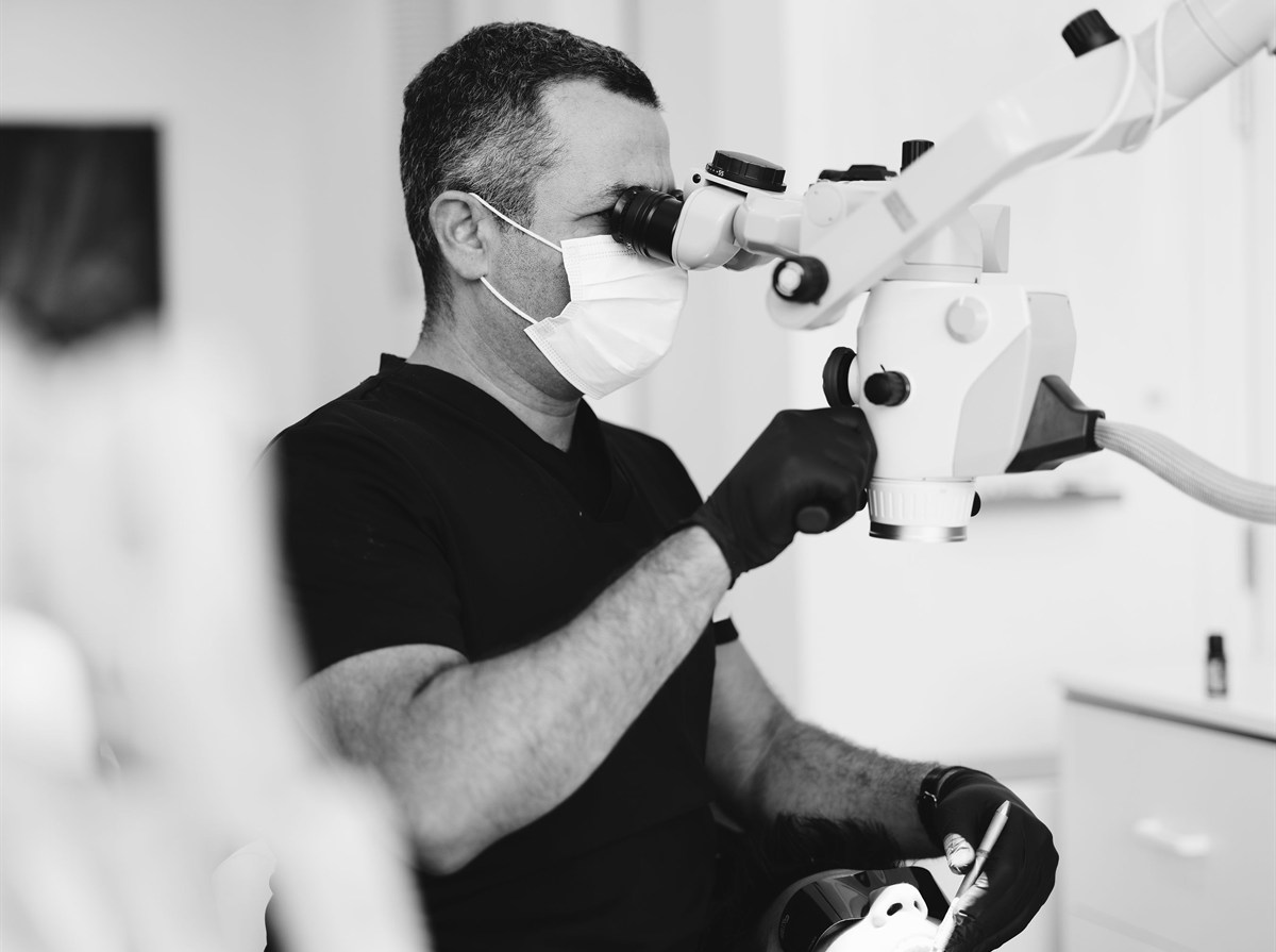 Dr. Rashad Riman examining a patient under a surgical microscope at ELEV8 in Beverly Hills
